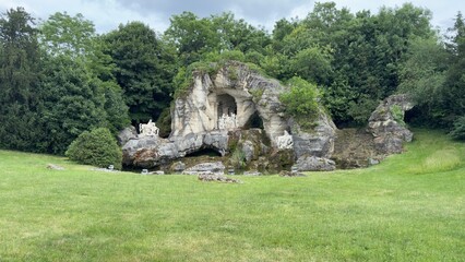 Grotto with Statues and Lush Green Lawn