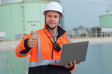 Engineer at LNG Facility Holding Laptop
