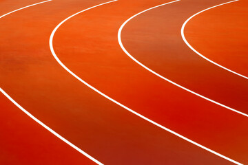 Red running track lanes with curved white lines, outdoor sports stadium surface, athletic raceway path close up, synthetic rubber ground texture background, fitness competition training field perspect