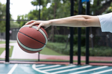 Young Man Holding Basketball on Court
