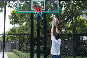 Young Man Aiming Basketball Shot at Hoop