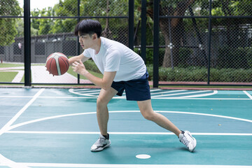 Young Man Playing Basketball on Outdoor Court