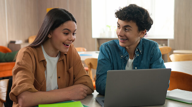 Two friends classmates partners project education school university Caucasian man woman girl guy boy female male students schoolboy schoolgirl together studying learning laptop computer talking smile