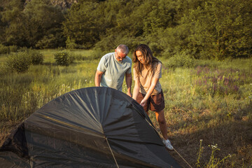 happy caucasian family prepare camping together and install tent