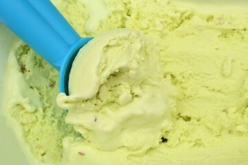 Green pistachio ice cream with blue plastic spoon