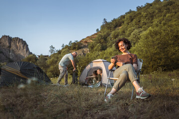 mature woman hold cup and use mobile phone enjoy on camping