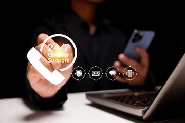 A person holds a phone with a 24/7 customer support icon, surrounded by digital service icons,...