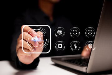 A person interacts with a virtual interface selecting a software update icon, with a laptop in the...