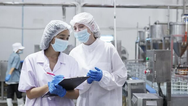 Food processing workers shaking hands in factory