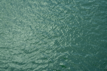 Obraz na płótnie Canvas Top view of calm water surface texture with soft natural ripples. Background for eco-friendly design, peaceful concepts, and water sustainability. Aerial view blue green lake surface water background.