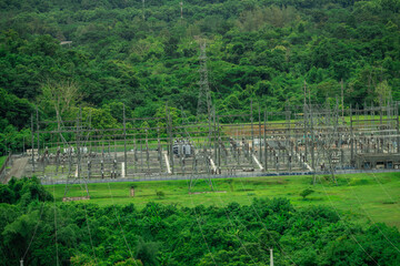 Electrical power station at hydroelectric dam facility with green forest. Sustainable renewable...