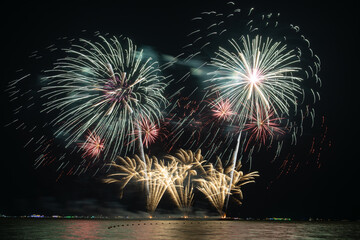 Multicolored Fireworks Exploding Over Water