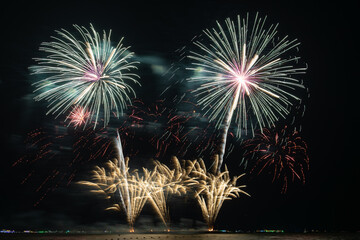 Multicolored Fireworks Exploding Over Water