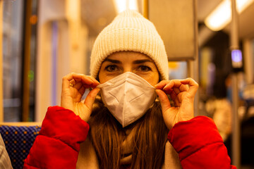 Young woman in a medical mask sitting in a city transport