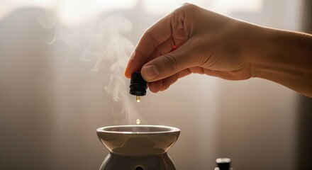 Hand dropping essential oil into ceramic diffuser with rising steam