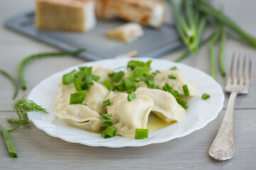 Healthy serving of dumplings with potatoes on a wooden surface