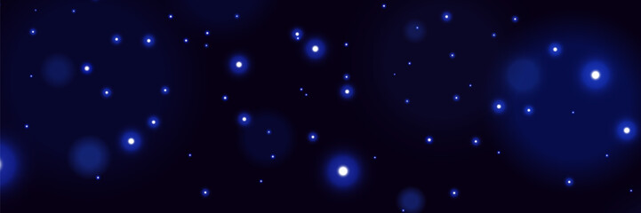 Blue glowing particles on dark background with soft bokeh light effect and dreamy cosmic atmosphere