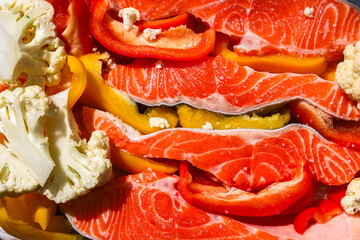 Fresh salmon and colorful vegetables ready for a healthy meal preparation
