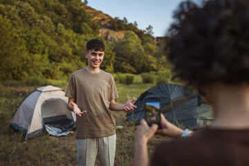 young teenage boy v-logger filming video blog on camping trip