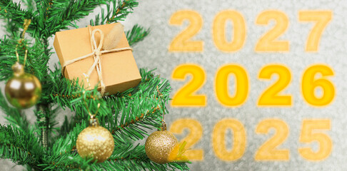 Happy New Year 2026 anniversary. Transition from 2025 to new year 2026 concept image with golden ball ornament on Christmas tree.