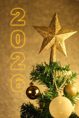 Close-up shot of a Christmas tree with a star on top, ornamented with yellow spheres and lights. Preparation for celebrate new year concept idea. 2025	