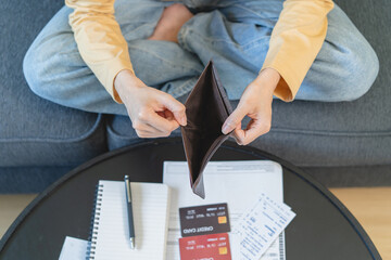 debts in first jobber, Young woman open wallet find it empty with many invoice and credit card on...