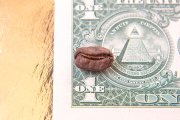 Detailed shot of a cracked coffee bean placed on a one-dollar bill, showcasing the contrast between...