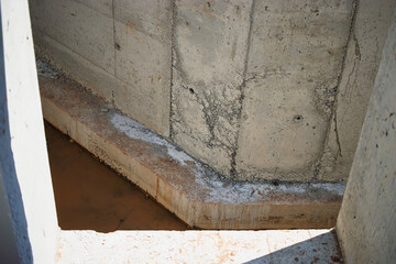 Concrete construction site in urban area showcasing foundation work during daylight