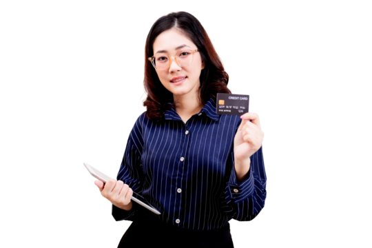 Asian young beautiful woman wearing glasses holds a credit card in one hand and a tablet in the other, dressed in a striped shirt, smiling confidently at the camera.
