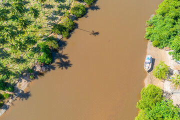 Boat on one margin of the Rio Salgado (Salgado river), with palm trees on the other margin.