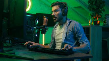 Emotional angry mad furious talking in microphone video game loss addiction Caucasian guy male man streamer gamer wearing headphones playing virtual battle lost fail internet computer at night home