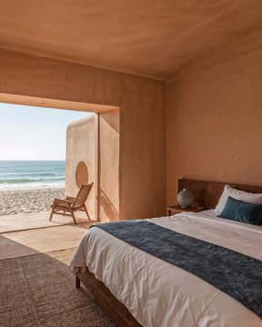 Sleeping area of a Native American adobe house that fuses ancient architecture with minimalism in front of beach designed in terracotta and ocean blue theme