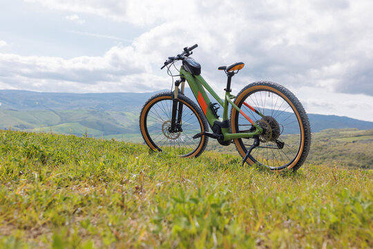 Explore the stunning landscape of Tuscany while mountain biking on a sunny day. The rolling hills and vibrant greenery provide a perfect backdrop for an outdoor adventure.