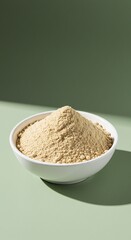 Pale Yellow Powder in White Bowl on Sage Green Background