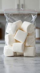 White Marshmallows in a Clear Resealable Bag on a Marble Counter