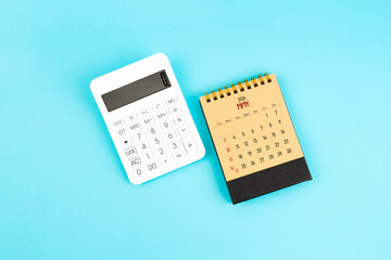 May 2026 brown caculator and white calculator on blue color background.