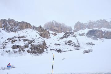 Obraz premium March 2025: view of Pordoi Pass and snowy road, Dolomites, Italy