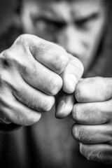 Triggered emotion expression. People showing emotion with clenched fists and shaking shoulders in grayscale.