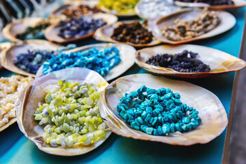 Colorful semi-precious gemstone beads displayed in shells at a street souvenir shop in Izmir, Turkey