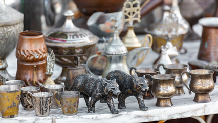 Antique street shop display with traditional Turkish metal cups and figures, Mudanya, Turkey