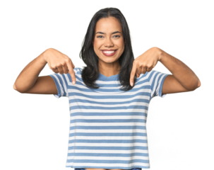 Young Latina posing in studio points down with fingers, positive feeling.