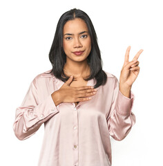 Simple portrait of a young Latina taking an oath, putting hand on chest.