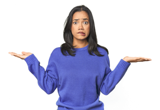 Simple portrait of a young Latina confused and doubtful shrugging shoulders to hold a copy space.