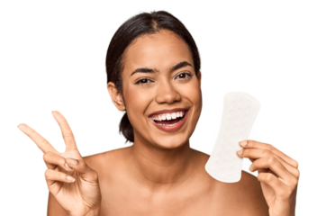 Filipino woman with sanitary pad in studio joyful and carefree showing a peace symbol with fingers.