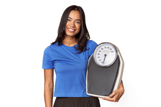 Filipino woman with scale in studio happy, smiling and cheerful.