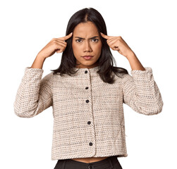 Young filipino woman focused on a task, keeping forefingers pointing head.