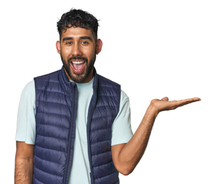 Young Hispanic man isolated impressed holding copy space on palm.