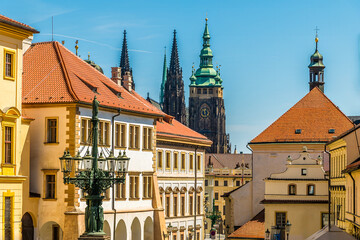 Obraz premium A view past buildings towards the center of the castle complex in Prague in springtime