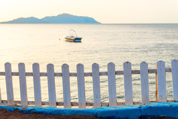 Fototapeta premium Seascape of Tiran Island in Red Sea with white wooden decorative fence on the shore. Egypt