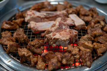 Korean Style Barbecue on stainless grill. BBQ rare meat with soft focus